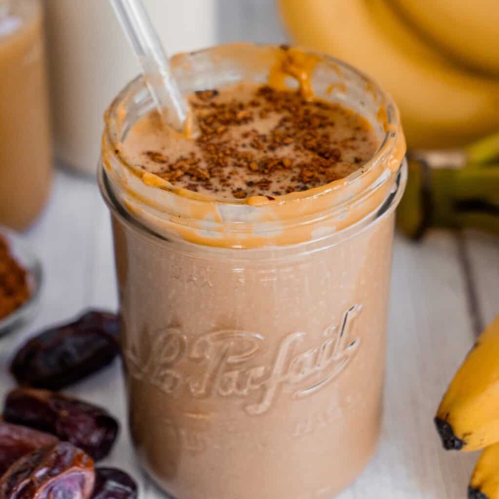 A thick chocolate peanut butter banana smoothie served post-workout, showing a rich and creamy texture.