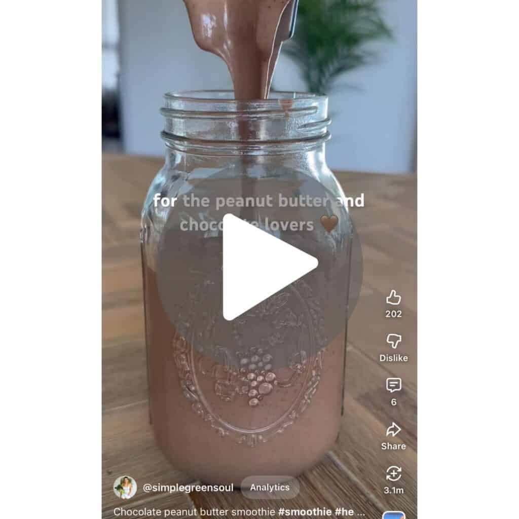 A video screenshot of a thick chocolate peanut butter banana smoothie being poured into a glass, with a prompt to watch the easy recipe tutorial on YouTube.