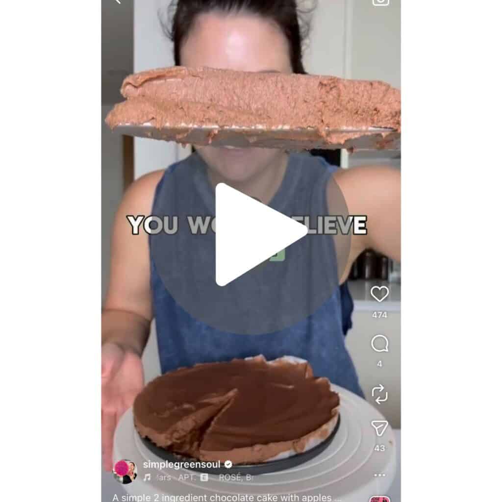 Georgia Papas holding a slice of 2-ingredient chocolate cake made with apples and dark chocolate, showing the fudgy mousse texture from her viral social media video.