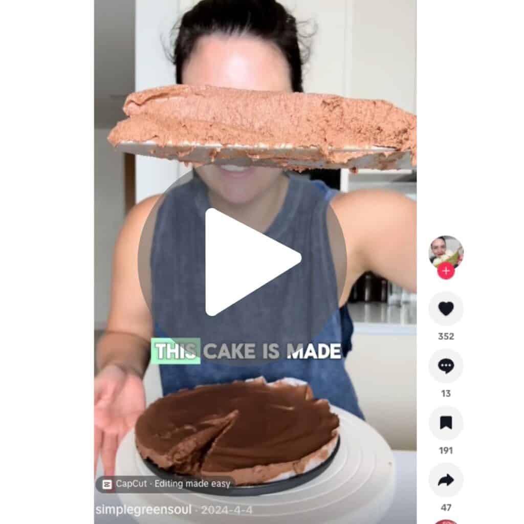 Georgia Papas holding a slice of 2-ingredient chocolate cake made with apples and dark chocolate, showing the fudgy mousse texture from her viral social media video.