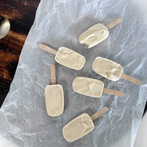 Dairy-free ice-cream popsicles made from boiled cempedak seeds resting on white parchment paper.