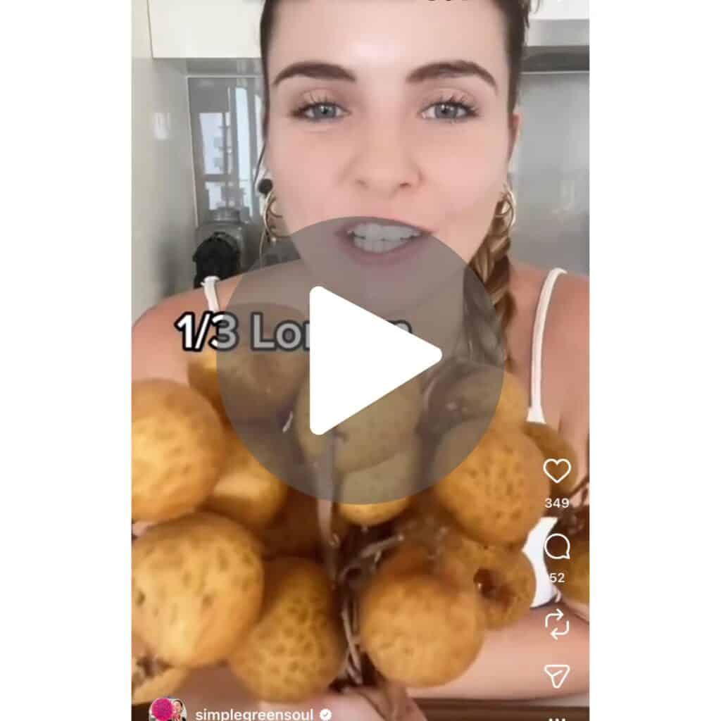 A screenshot of a girl holding a bunch of longan fruit