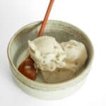 Creamy one-ingredient banana nice cream served in a bowl with a wooden spoon, made using this easy banana ice cream recipe in a food processor.
