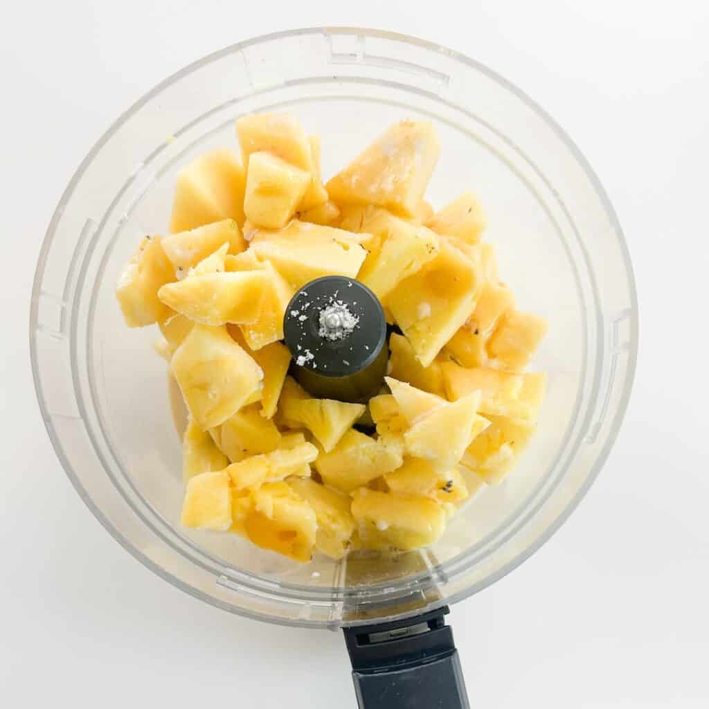 Frozen pineapple, coconut cream, maple syrup and salt combined in a food processor to make pineapple whip.