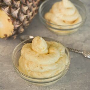 Homemade pineapple Dole Whip being blended, transferred to a piping bag and served in a bowl.