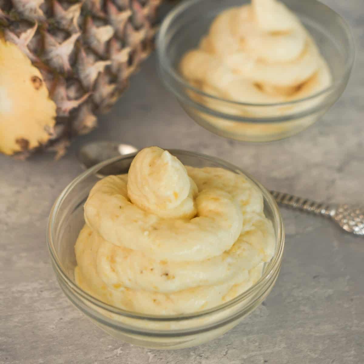 Homemade pineapple Dole Whip being blended, transferred to a piping bag and served in a bowl.